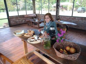 伊图萨因戈Wild Wetlands Lodge的坐在桌子上,吃着食物的女人
