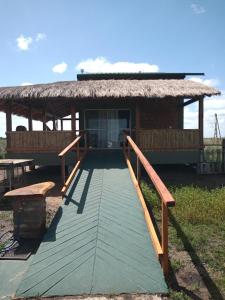 伊图萨因戈Wild Wetlands Lodge的通往茅草屋顶房屋的木制走道