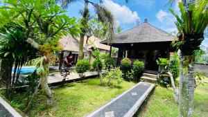 帕洋安Dong Loka Guesthouse Bali的一座带花园的房子,前面有一条路