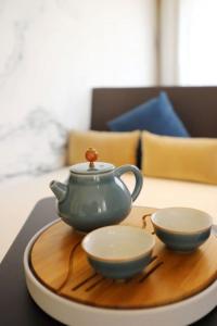 广州广州永庆坊瞻云精选酒店的茶壶和桌子上的盘子上的两个碗