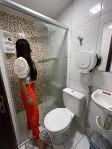 大坎皮纳Hotel Pousada Acauã Acesso através de escadas的站在浴室淋浴的女人