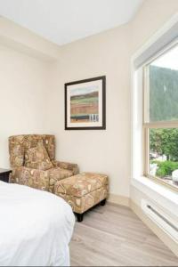 哈里森温泉Penthouse Lake Home - 3BR w/Amazing View & Deck!的一间卧室配有椅子、床和窗户