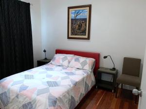 布罗肯希尔布罗肯希尔3号度假屋的卧室里一张带五颜六色的被子和椅子的床