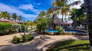 波拉马尔Hotel Margarita Village的一个带游泳池和棕榈树的度假村