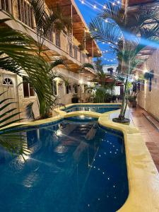 瓜亚比托斯Bungalows Las Glorias的棕榈树建筑中的一个大型游泳池