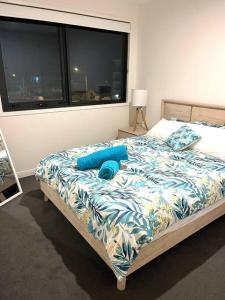 黄金海岸Casa De Mork - Entire 3 Storey Beach Villa的一间卧室配有一张带蓝色床单的床和一扇窗户。