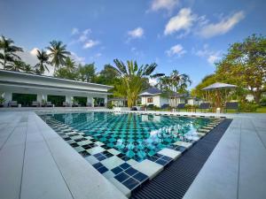 苏梅岛Moorea Boutique Resort Samui的一个带格子地板的游泳池和一座建筑