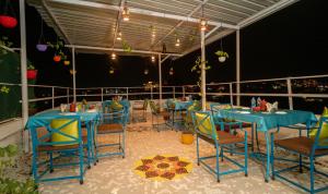 乌代浦Soham Haveli Udaipur的阳台餐厅,配有蓝色的桌椅
