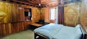 奈尼塔尔Sukoon- A Lake view BnB的一间卧室配有一张床和一台电视
