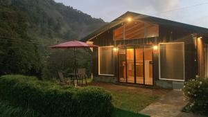 圣赫拉多德多塔Los Lagos Lodge的一个带桌子和雨伞的小房子