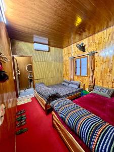 Na ThônPura Homestay的一间卧室配有两张床,铺有红地毯