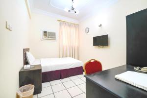 麦纳麦OYO 124 Al Salam Palace Hotel的配有一张床和一张书桌的酒店客房