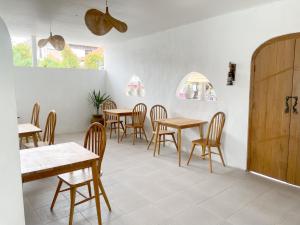 ToyapakehLa PAYANA House Penida的餐厅设有木桌、椅子和窗户。
