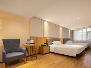 广州维度酒店(广州北京路步行街越秀公园店)的酒店客房,配有两张床和椅子
