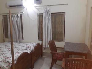 普里Sudha Kutir Puri的卧室配有床、桌子和窗户。