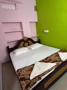 SrīsailamHotel R residence的一间卧室配有一张带绿色墙壁的床