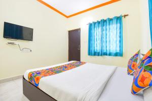巴加FabExpress Shanel Beachside Resort的一间卧室配有一张床和一台平面电视