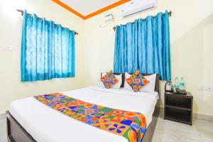 巴加FabExpress Shanel Beachside Resort的一间卧室设有两张床和蓝色窗帘