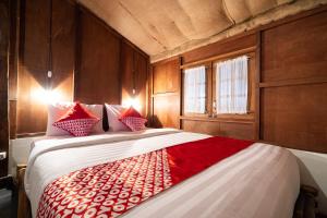 马格朗OYO 2393 Putroyono Homestay的一间卧室配有一张带红色和白色枕头的大床