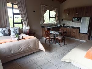 MkuzeUmkhaya Lodge的一间卧室配有一张床铺和一张桌子,还设有一间厨房