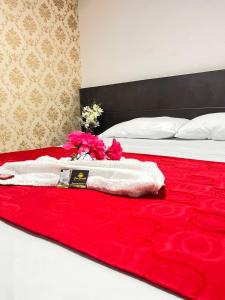 内瓦Hotel Boutique Casa Dorada的一张带红白色毛巾和鲜花的床