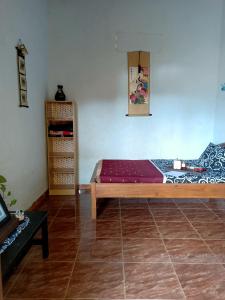 KetapangIjenBromo Hub Omyah Isun Hub的卧室配有木床和瓷砖地板。