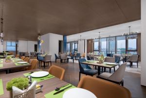 广州广州洛溪希尔顿欢朋酒店的餐厅设有桌椅和窗户。