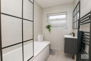 利物浦Newly Renovated 3 Bedroom House with Parking by Amazing Spaces Relocations Ltd的白色的浴室设有浴缸和水槽。