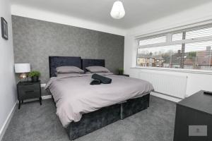 利物浦Newly Renovated 3 Bedroom House with Parking by Amazing Spaces Relocations Ltd的一间卧室设有一张大床和一个窗户。