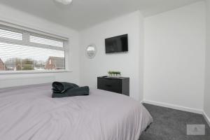 利物浦Newly Renovated 3 Bedroom House with Parking by Amazing Spaces Relocations Ltd的白色卧室配有床和平面电视