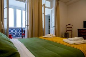 波尔图Casa Velha Guesthouse的一间卧室配有一张大床和毛巾