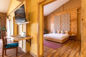 博卡拉Sunshine Resort Pokhara的一间卧室配有一张床和一张带笔记本电脑的书桌
