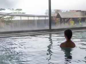 草津草津温泉度假酒店(Kusatsu-Onsen Hotel Resort)的坐在水塘里的男人