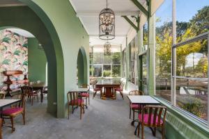 维多利亚山Victoria and Albert Guesthouse的餐厅设有桌椅和窗户。