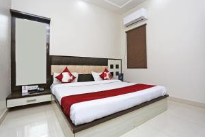 SikandraOYO KN Plaza的一间卧室配有一张带红色和白色枕头的大床