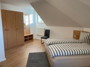 巴特尚道Apartmenthaus Zentral Bad Schandau的一间卧室配有一张床和一把椅子