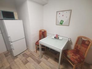 韦尼格罗德Günstige, moderne Zimmer im Wanderparadies的厨房配有白色的桌子和冰箱。