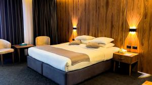 安曼ٍSandy Prime Hotel的一张大床,位于带两个灯的酒店客房内