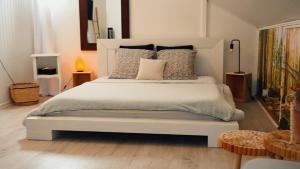 卡夫尔高原Les Jardins de Nicole的卧室配有带枕头的大型白色床