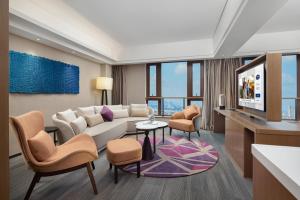 广州广州洛溪希尔顿欢朋酒店的客厅配有沙发、椅子和电视