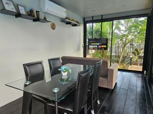 合艾My Home Pool Villa Hatyai的一间设有玻璃桌和椅子的用餐室