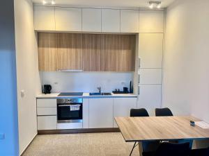 采列Diamant apartment pri sejmu MOS的厨房配有白色橱柜和木桌