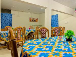 库马西PRESTIGE Guesthouse ,Ksi的一间用餐室,配有一张桌子和椅子,配有蓝色和黄色的桌布