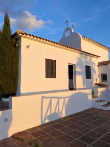 马拉加El Cielo, Cortijo en el corazón de las montañas的上面有十字架的白色建筑