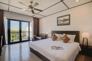 会安Golden Pearl Hoi An Hotel的一间卧室设有一张床和一个阳台