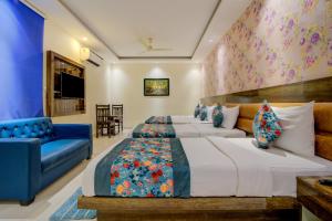 新德里SMART PLAZA HOTEL-At Airport的一间卧室配有两张床和蓝色的沙发