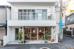 Dejimamachihotel & cafe ksnowki的白色的房子,上面设有阳台