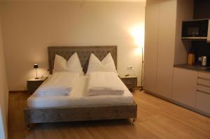 因斯布鲁克myQuartier Luxury Hideaways的一间卧室配有带白色床单和枕头的床。