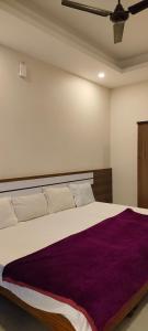 PanamaramRemarita Holidays的一间卧室配有一张大床和紫色毯子
