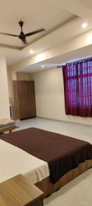 PanamaramRemarita Holidays的一间卧室配有一张大床和紫色窗帘